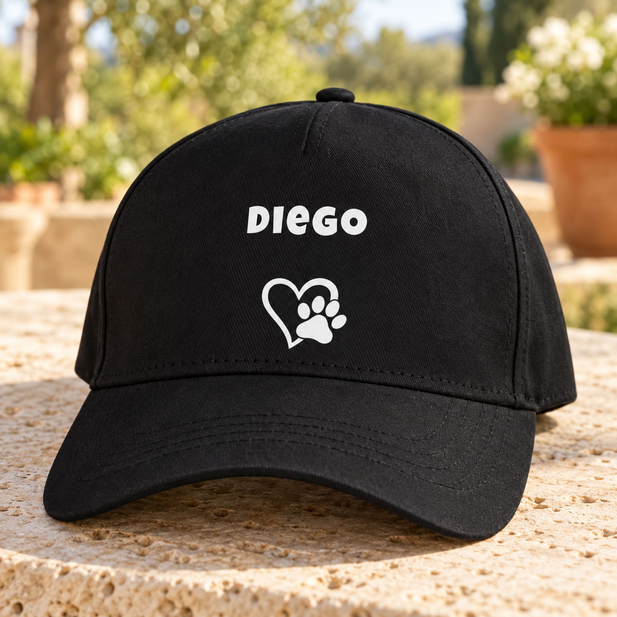 Cappellino nero con il nome del cane “Diego” e un cuore con impronta di zampa.