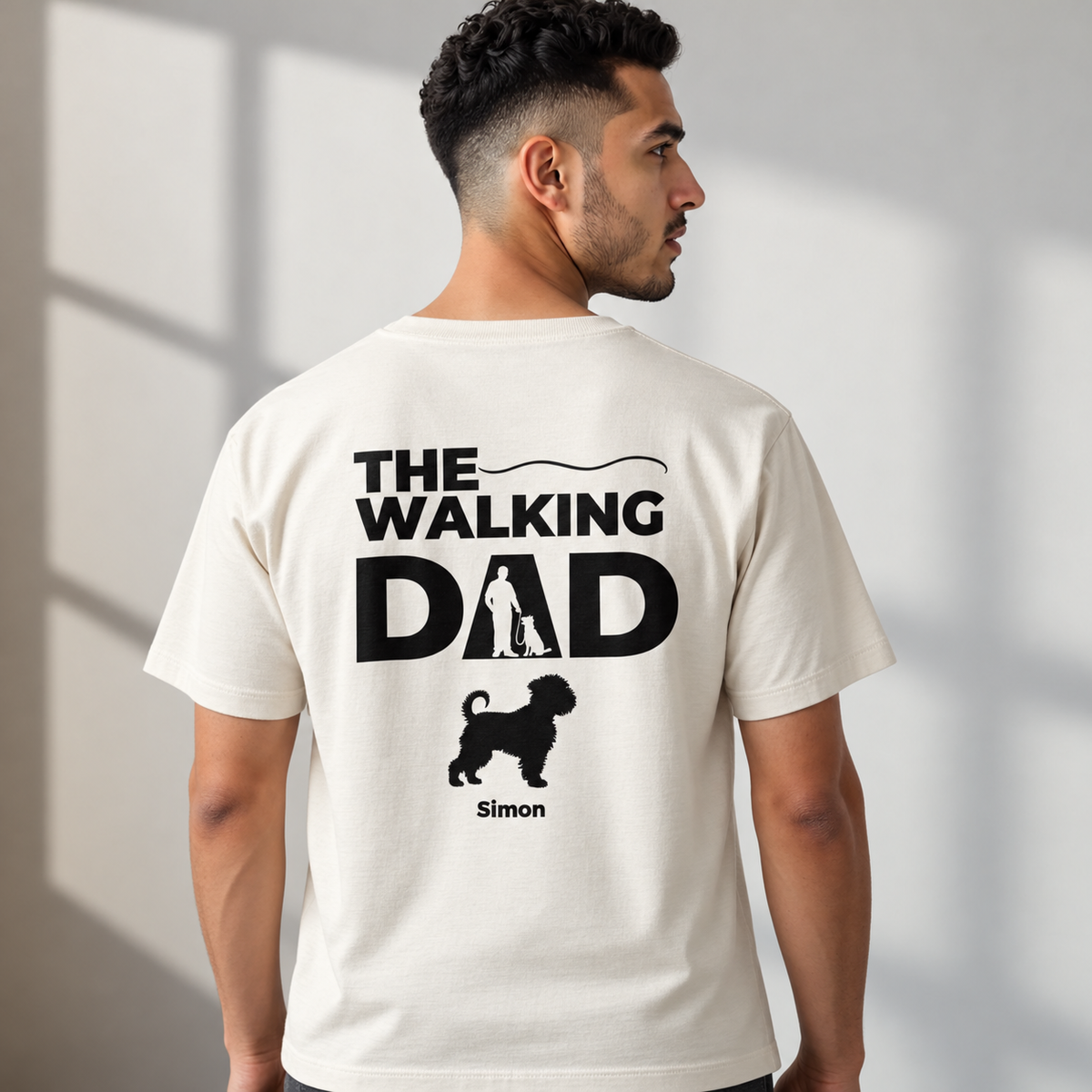 T-shirt beige con la scritta "THE WALKING DAD", silhouette di un uomo con un cane e il nome "Simon".