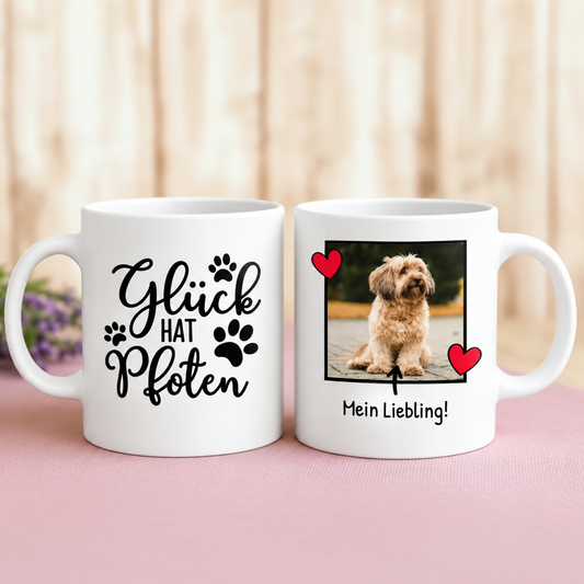 Tazza bianca personalizzata con motivo di cane, la frase "Glück hat Pfoten" e foto.