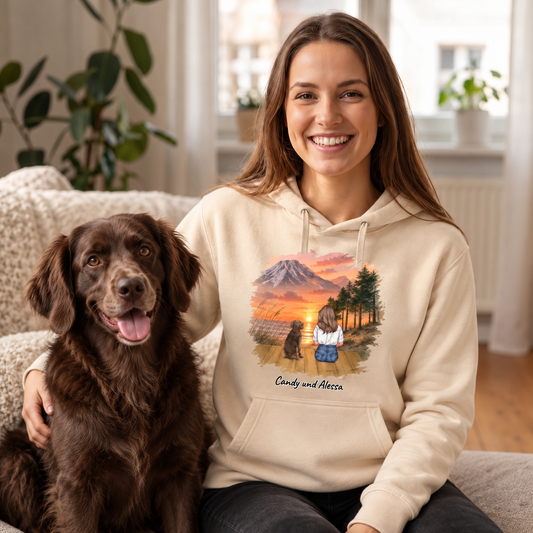 Felpa con cappuccio beige con motivo personalizzato di una donna e il suo cane davanti a un paesaggio montano.