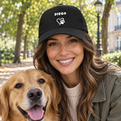 Cappellino nero con il nome “Diego”, cuore e zampa, indossato da una donna sorridente con un golden retriever.