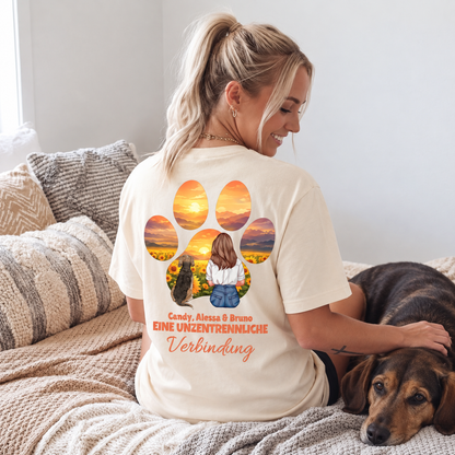 T-shirt beige con stampa grafica di una ragazza e un cane, circondati da tramonto e fiori.