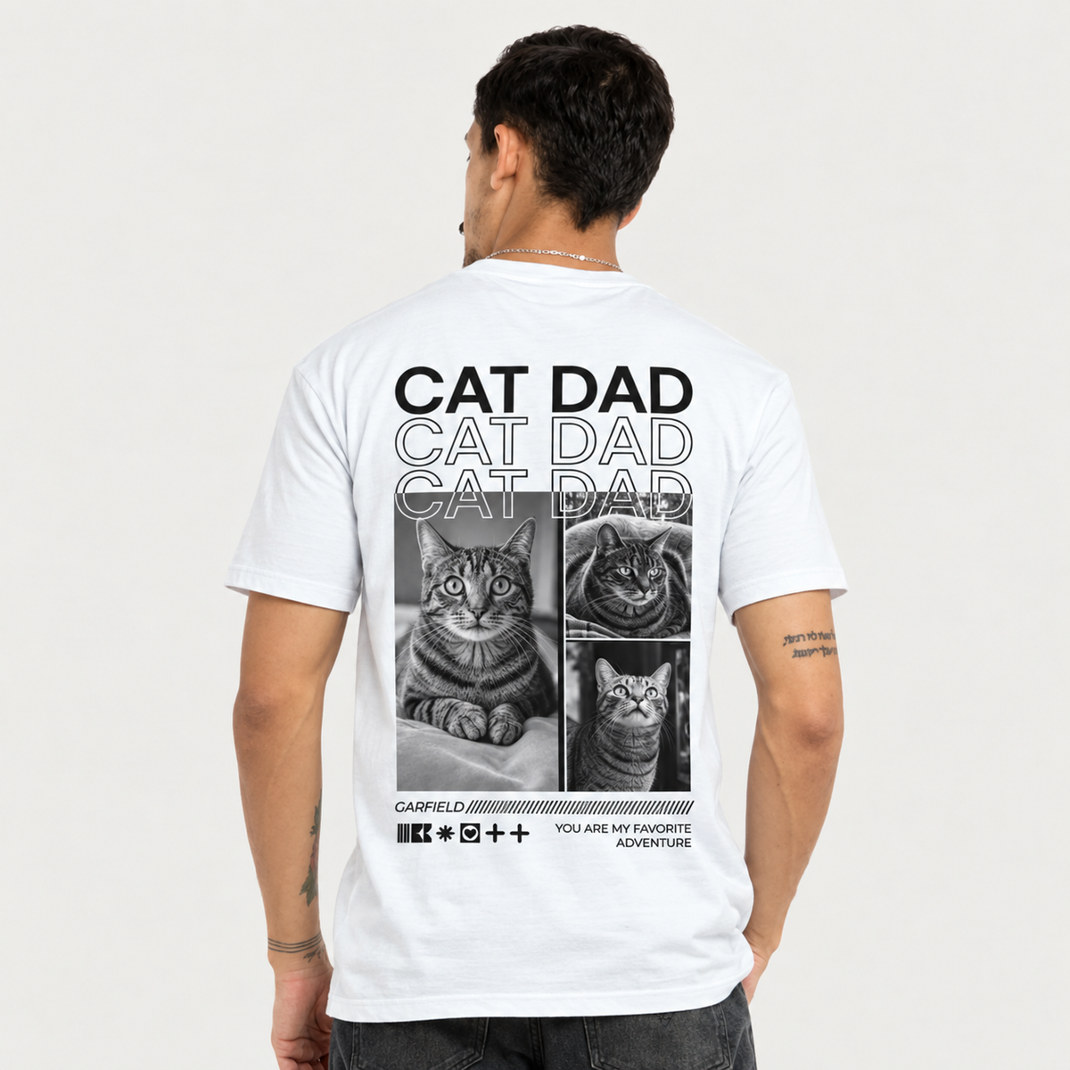 T-shirt bianca con stampa nera, sul retro foto di gatti e scritta "CAT DAD".