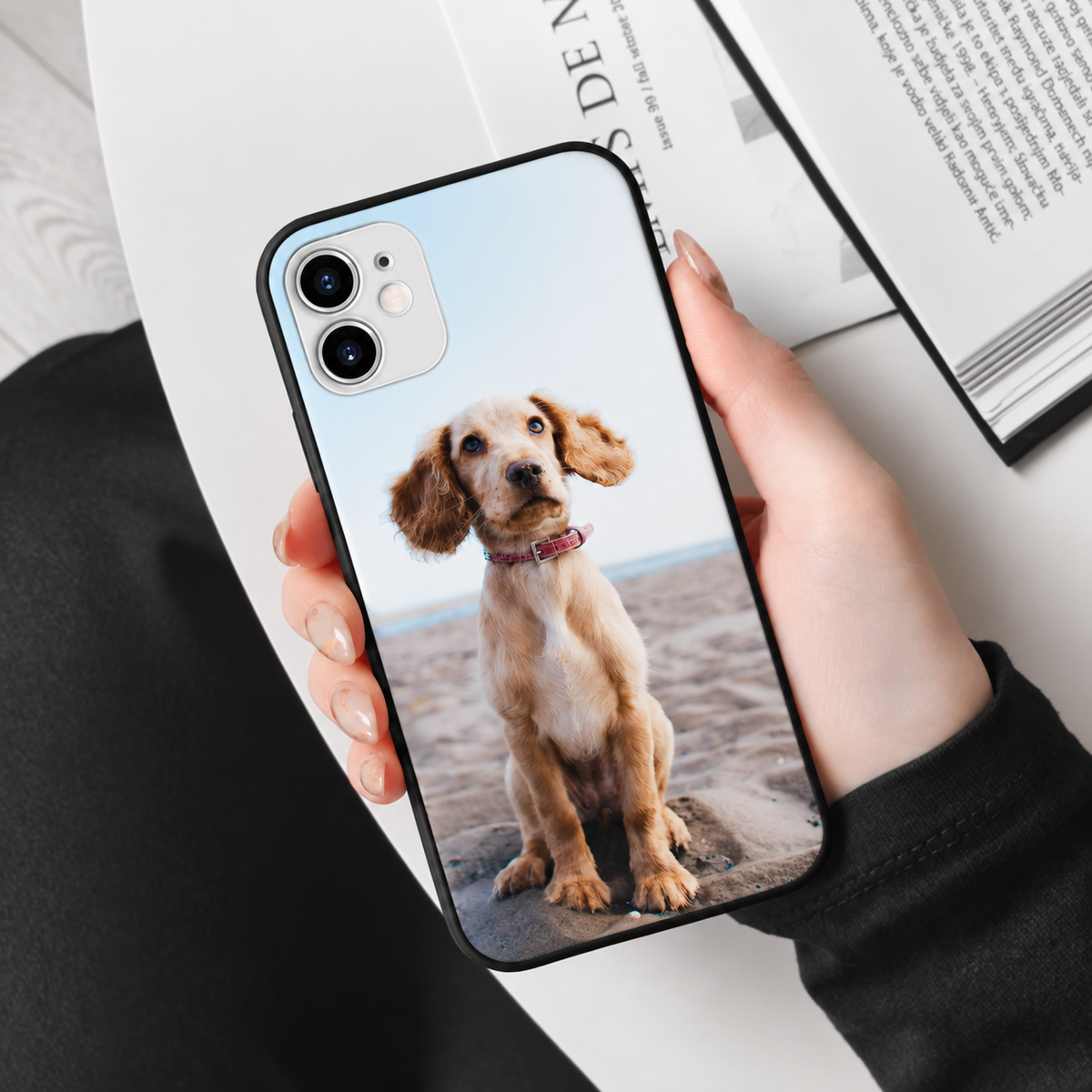 Cover nera personalizzata con foto di un cane, tenuta da una persona.
