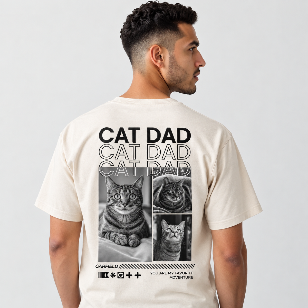 T-shirt beige con motivo di gatto e scritta "CAT DAD" sul retro.