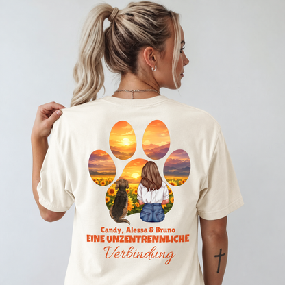 T-shirt beige con stampa a colori di una donna e un cane davanti a un paesaggio di girasoli.
