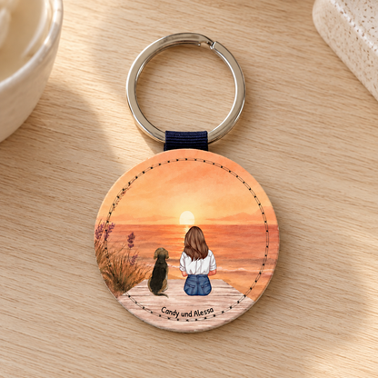 Portachiavi rotondo personalizzato con illustrazione di una donna e un cane al tramonto.