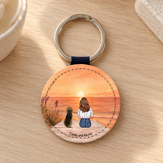 Portachiavi rotondo personalizzato con illustrazione di una donna e un cane al tramonto.