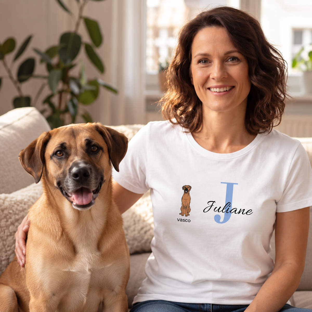 T-shirt bianca con iniziale personalizzata "J" e design di cane, indossata da una donna accanto a un cane.