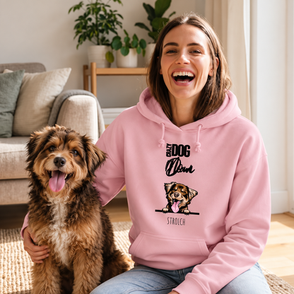 Donna sorridente con felpa rosa con motivo di cane, seduta accanto a un cane su un tappeto.