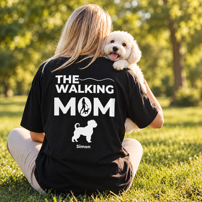 T-shirt nera personalizzata con la scritta "THE WALKING MOM" e motivo di cane. Seduta all'aperto.