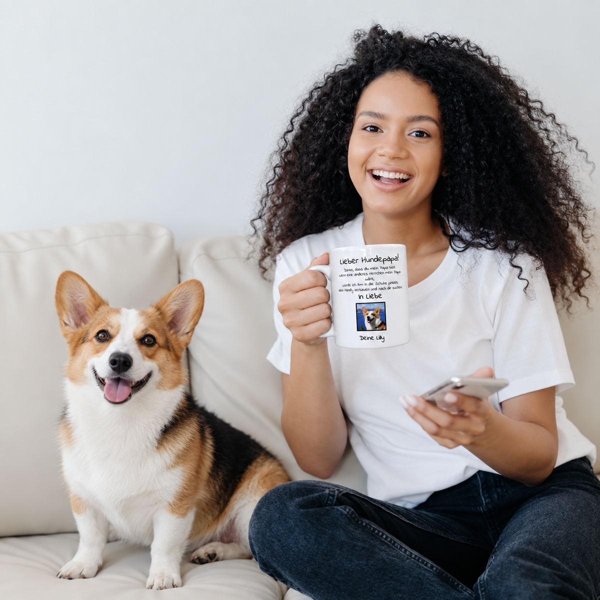 Persona con tazza personalizzata con la scritta "Lieber Hundepapa" e foto, seduta su un divano accanto a un cane.