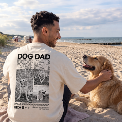 T-shirt beige con la scritta "DOG DAD", indossata da un uomo in spiaggia con un golden retriever.