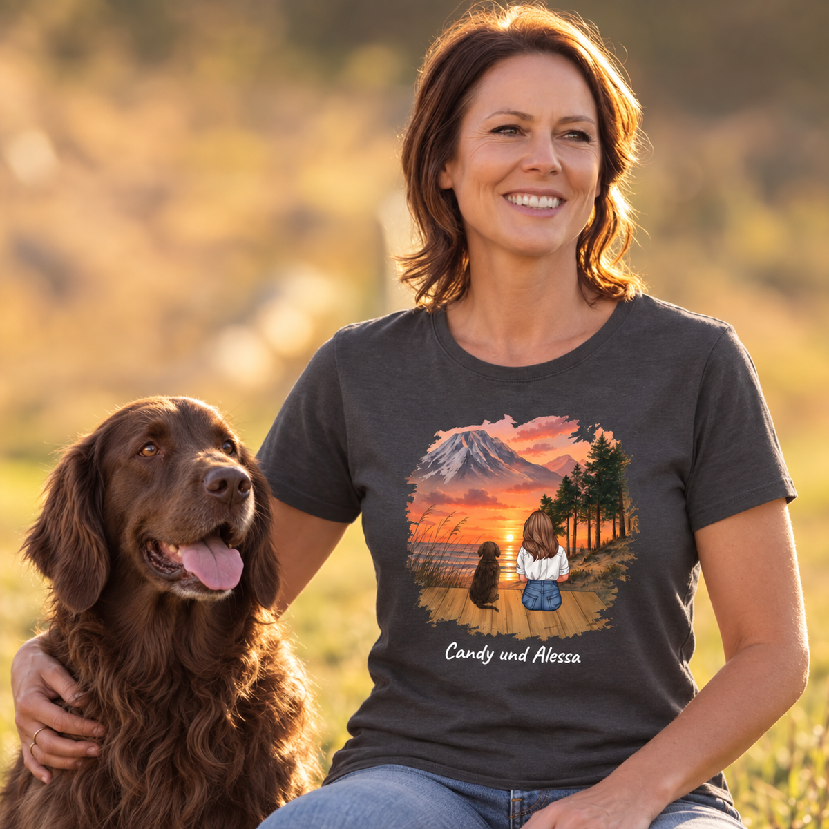 T-shirt grigio scuro con motivo personalizzato di una donna e un cane davanti a un paesaggio montano.
