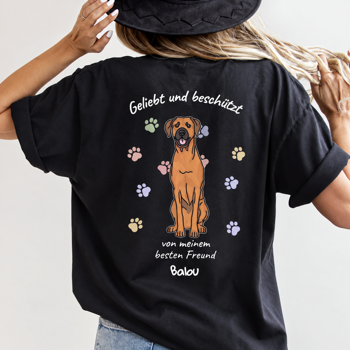 T-shirt nera con illustrazione di cane e la scritta "Geliebt und beschützt" sul retro.
