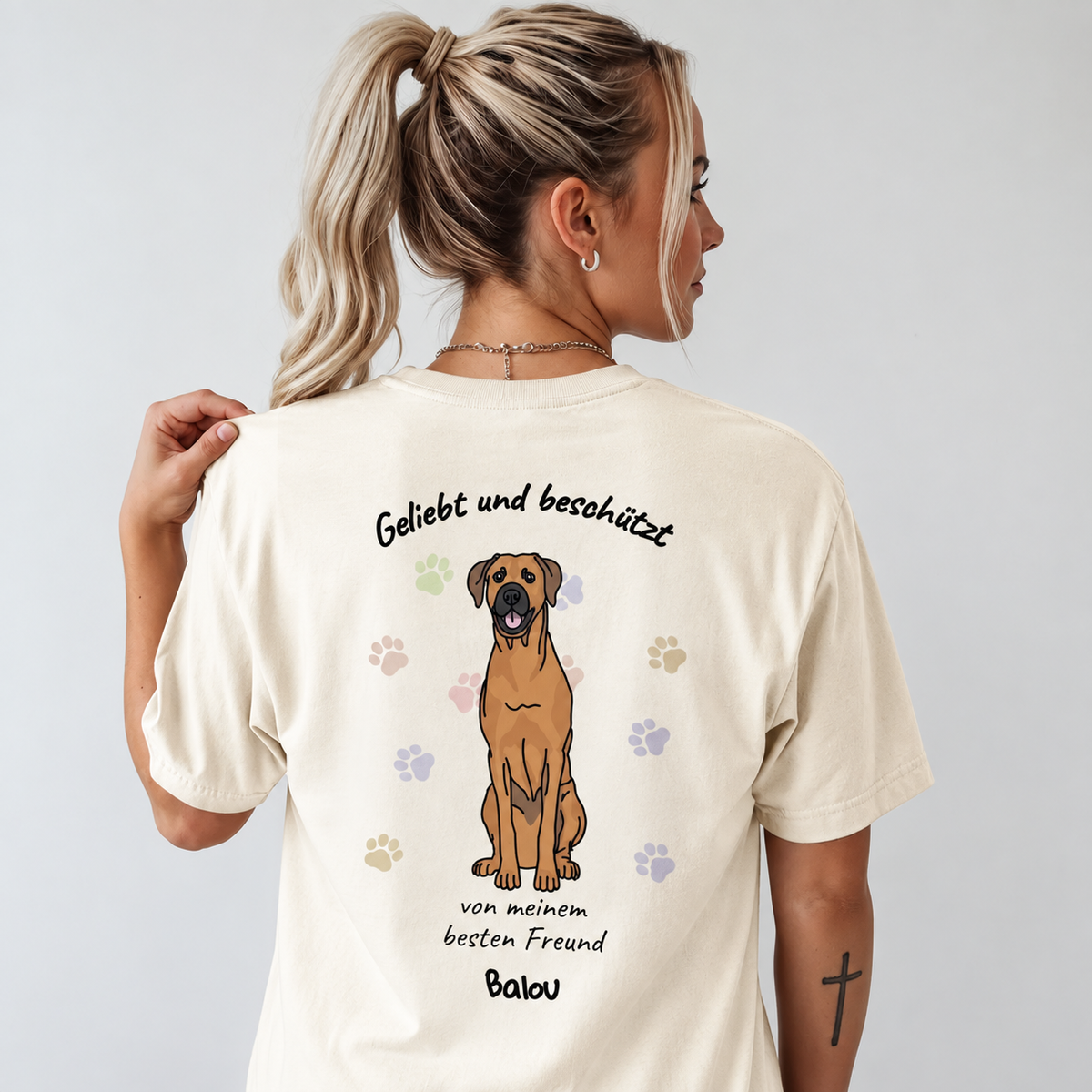 T-shirt beige con design di cane e il testo "Geliebt und beschützt" sul retro.