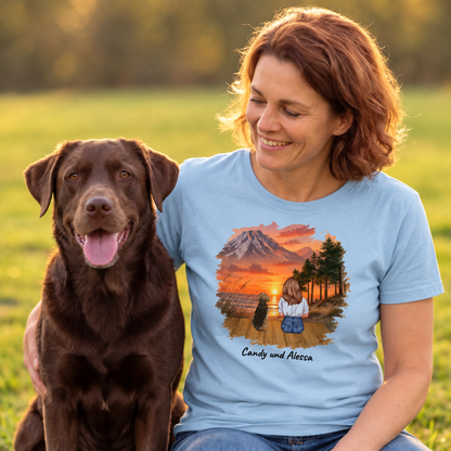 T-shirt blu con stampa grafica di una donna e il suo cane davanti a un paesaggio montano.