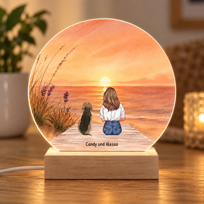 Luce notturna LED personalizzata con illustrazione di una ragazza e un cane in spiaggia al tramonto. Base in legno.