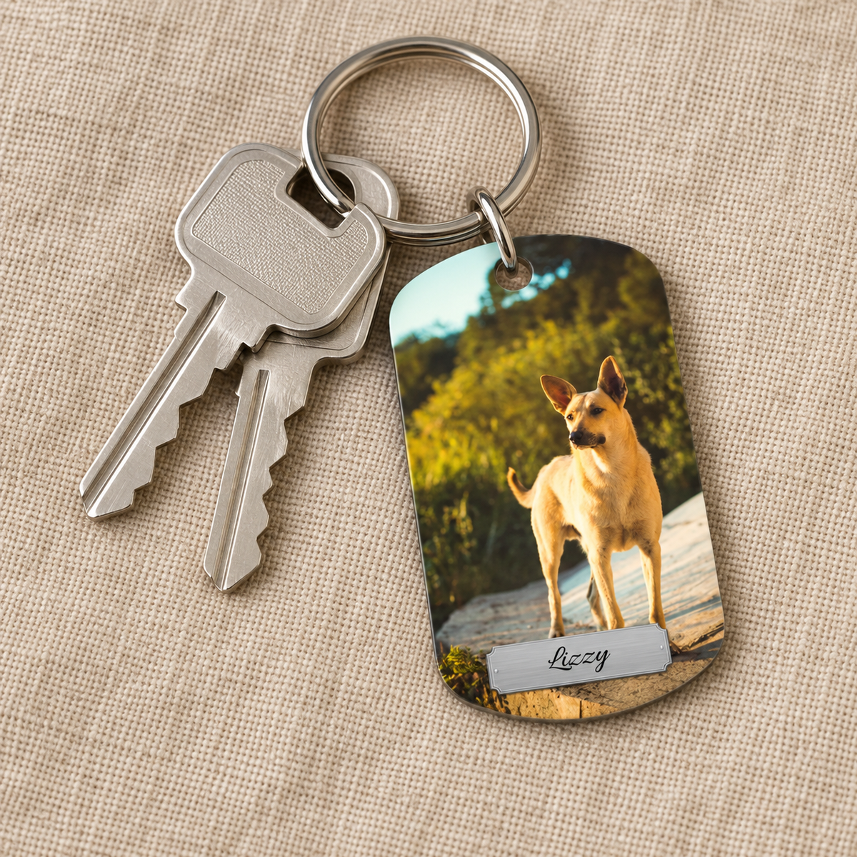 Portachiavi personalizzato con foto di un cane e nome inciso, con due chiavi.