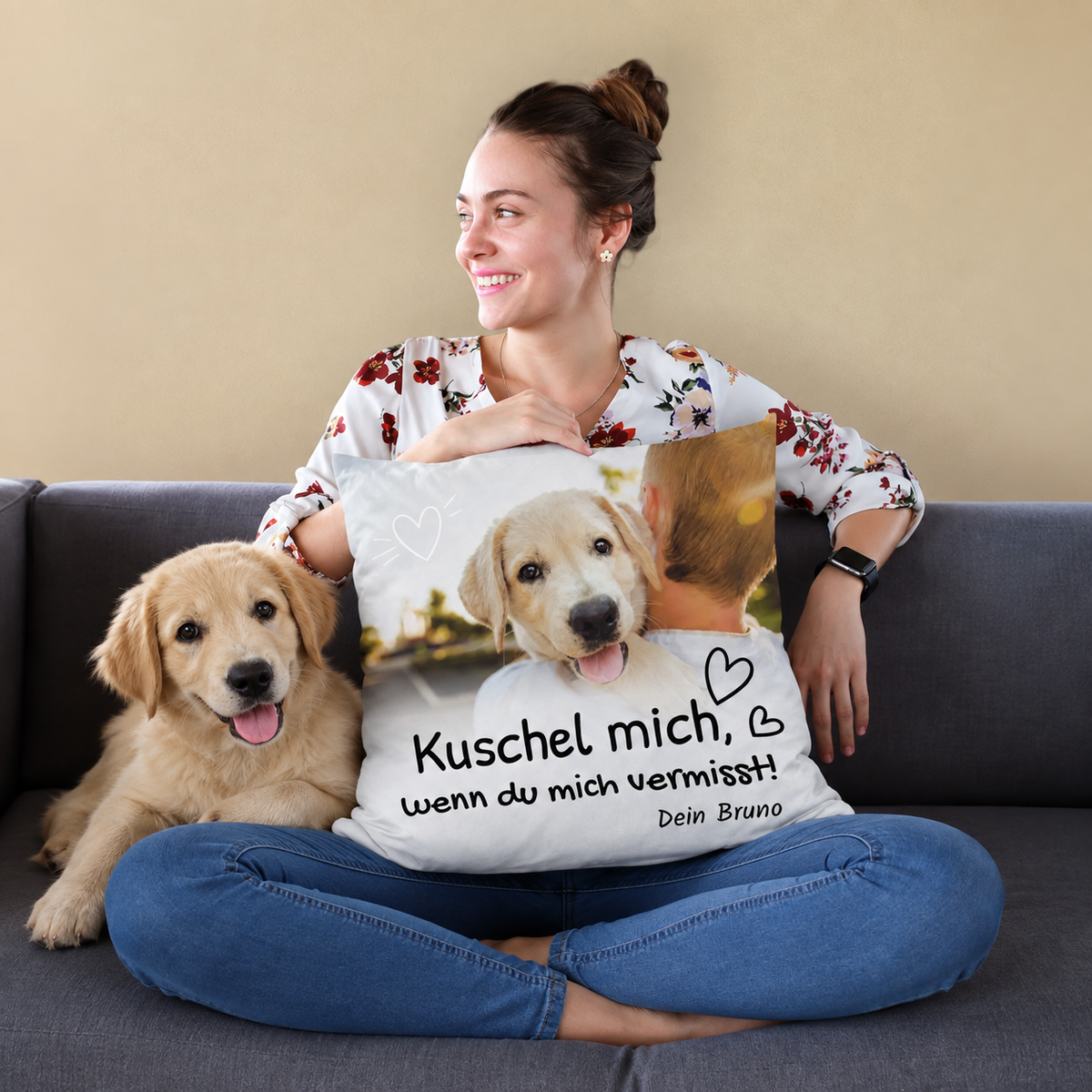 Cuscino con motivo personalizzato e la scritta "Kuschel mich, wenn du mich vermisst!", cane e donna su un divano.