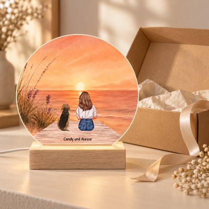 Luce notturna LED personalizzata con base in legno, illustrazione di una persona e un cane al mare al tramonto.