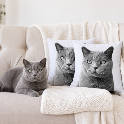 Due cuscini personalizzati con ritratti di animali in bianco e nero, accanto a un gatto grigio su un divano.