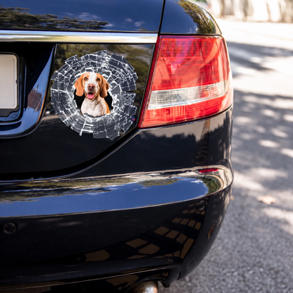 Adesivo per auto con la foto di un cane, circondata da un design a schegge di vetro su vernice nera.