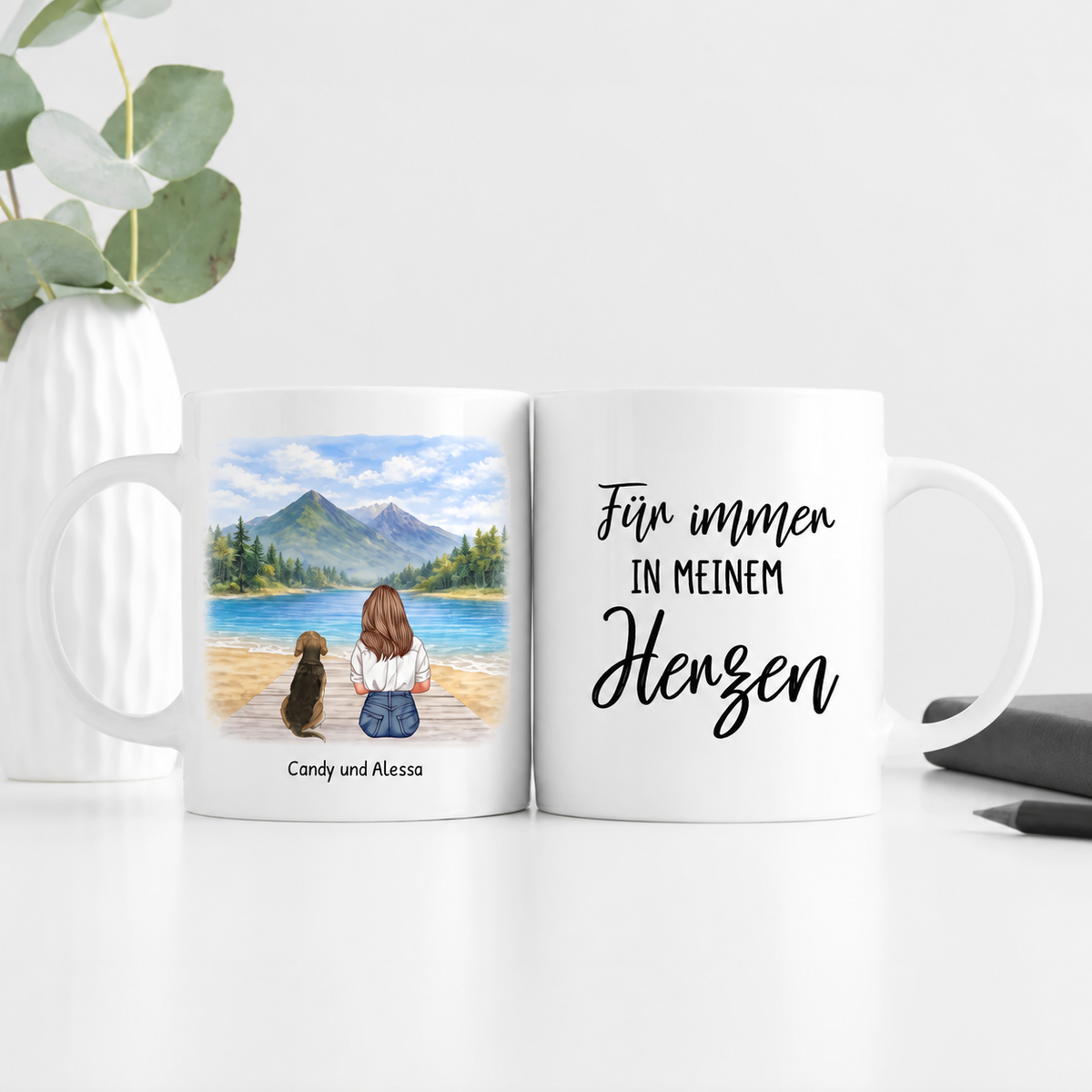 Tazza bianca personalizzata con illustrazione di una donna e un cane al lago e il testo "Für immer in meinem Herzen".