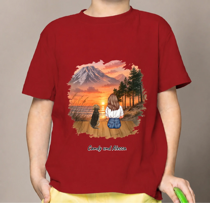 T-shirt per bambini rossa con stampa personalizzata di una persona e un cane in un paesaggio.