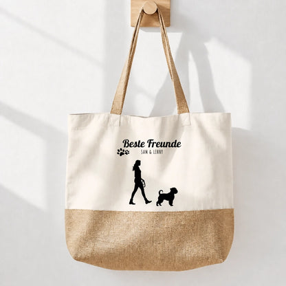 Borsa shopping beige in tessuto con fondo in iuta e stampa nera “Migliori amici”. Sagoma di una persona con un cane.