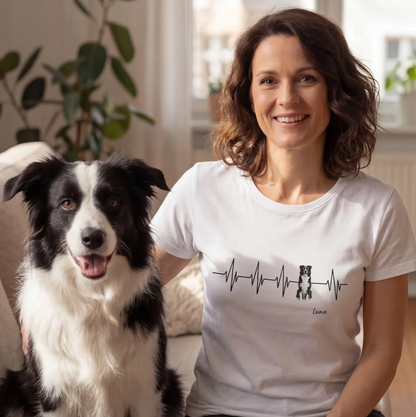 T-shirt bianca con design battito cardiaco e motivo di cane, personalizzabile. Donna seduta su un divano con un cane.