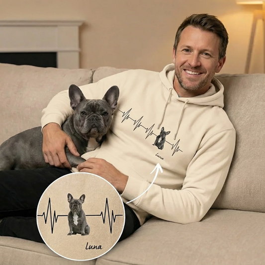 Felpa con cappuccio beige di qualità con motivo battito cardiaco e ritratto di cane, un uomo tiene un cane sul divano.