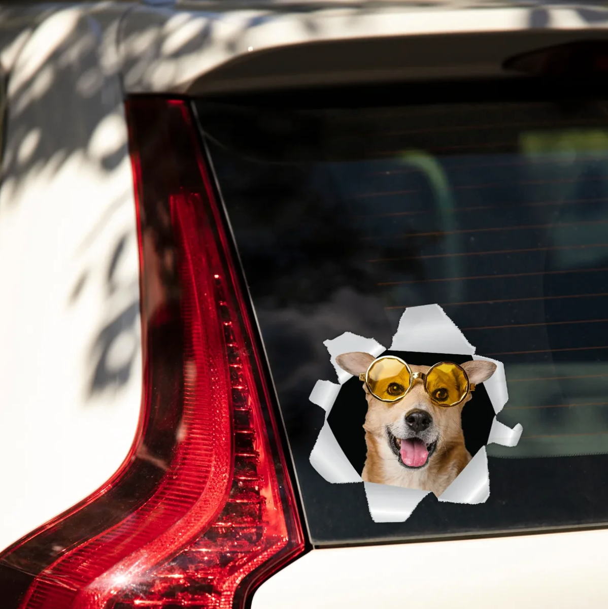 Adesivo per auto personalizzato con un cane con occhiali da sole che guarda da un finestrino strappato.