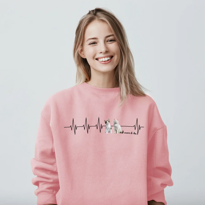 Felpa rosa con motivo battito cardiaco e illustrazioni di animali. La donna sorride.