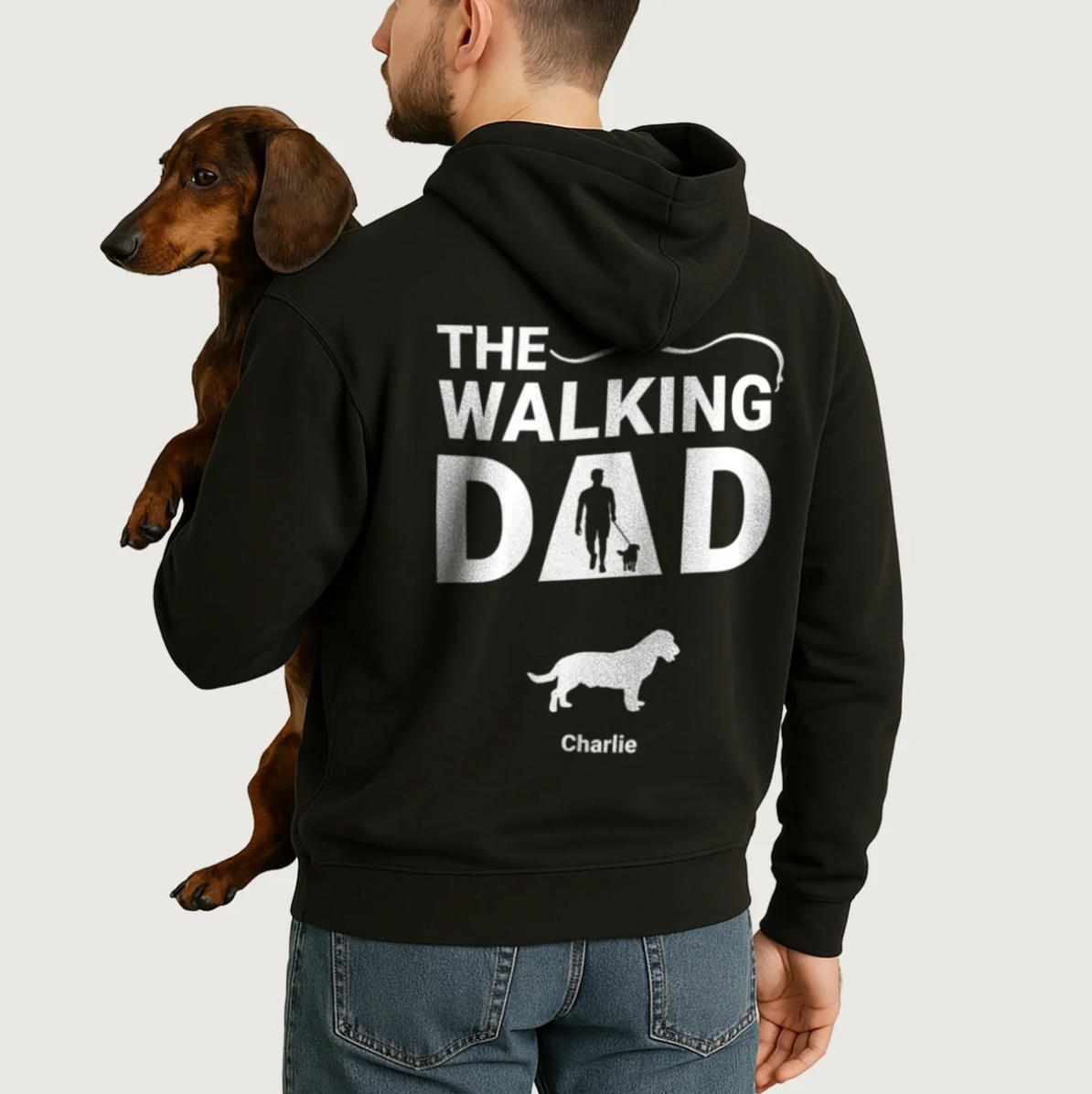 Felpa con cappuccio nera con stampa personalizzata "The Walking Dad" e motivi di cani. Indossata da un uomo con un cane.