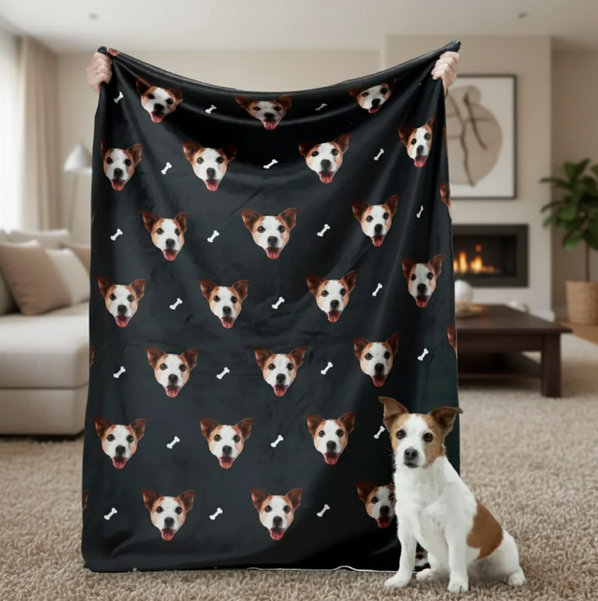 Coperta personalizzata con teste di animali su sfondo nero, tenuta da una persona con un cane in primo piano.