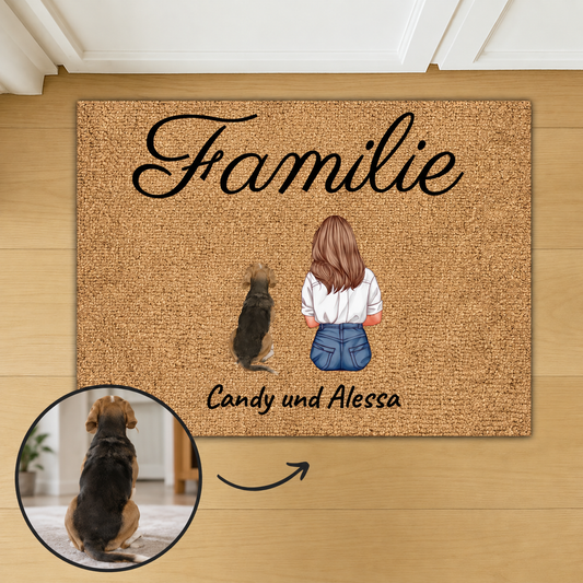 Zerbino in fibra di cocco personalizzato con la parola "Familie" e illustrazioni di una donna e un cane.