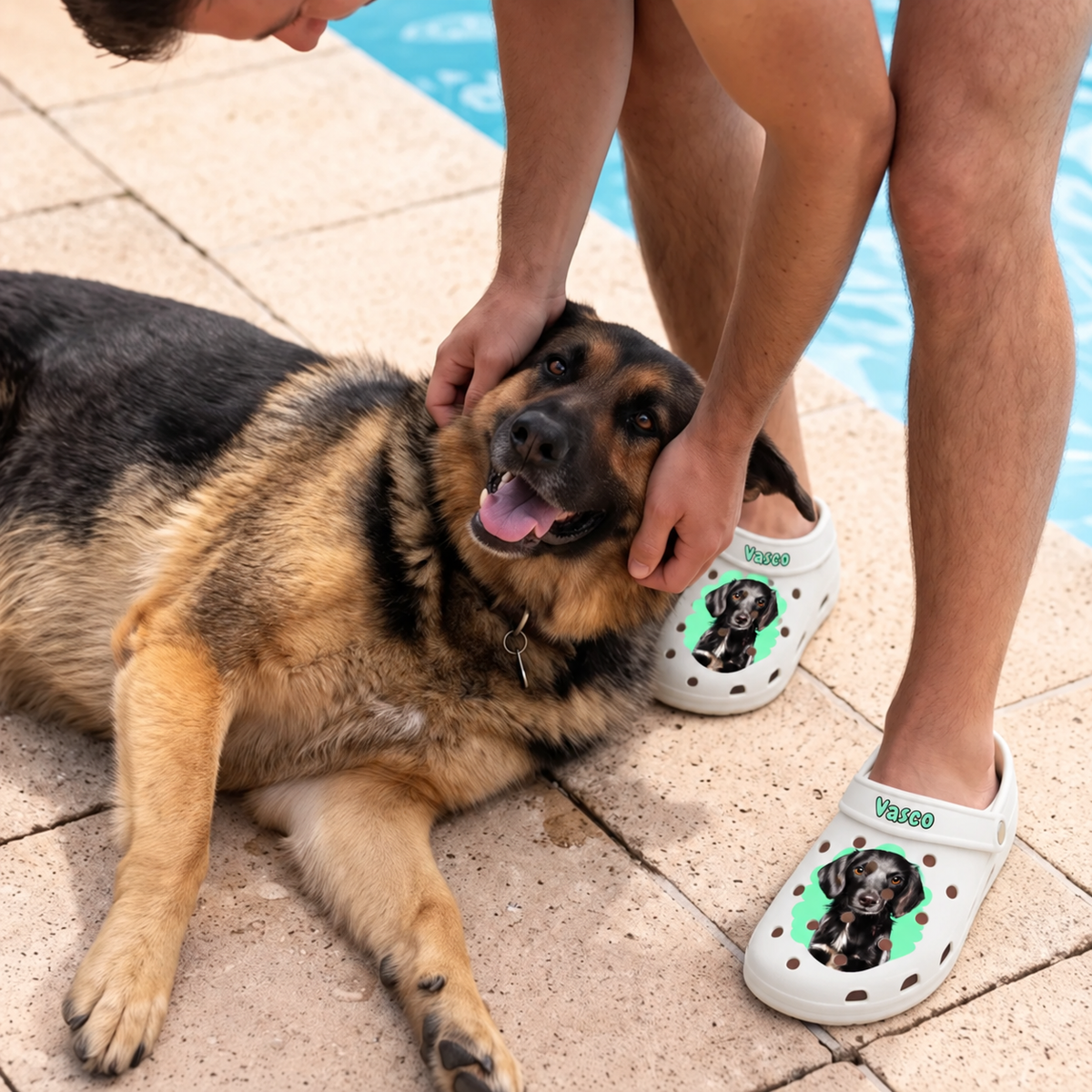 Persona che indossa zoccoli bianchi personalizzati con ritratto dell'animale, seduta accanto a un cane in riva all'acqua.